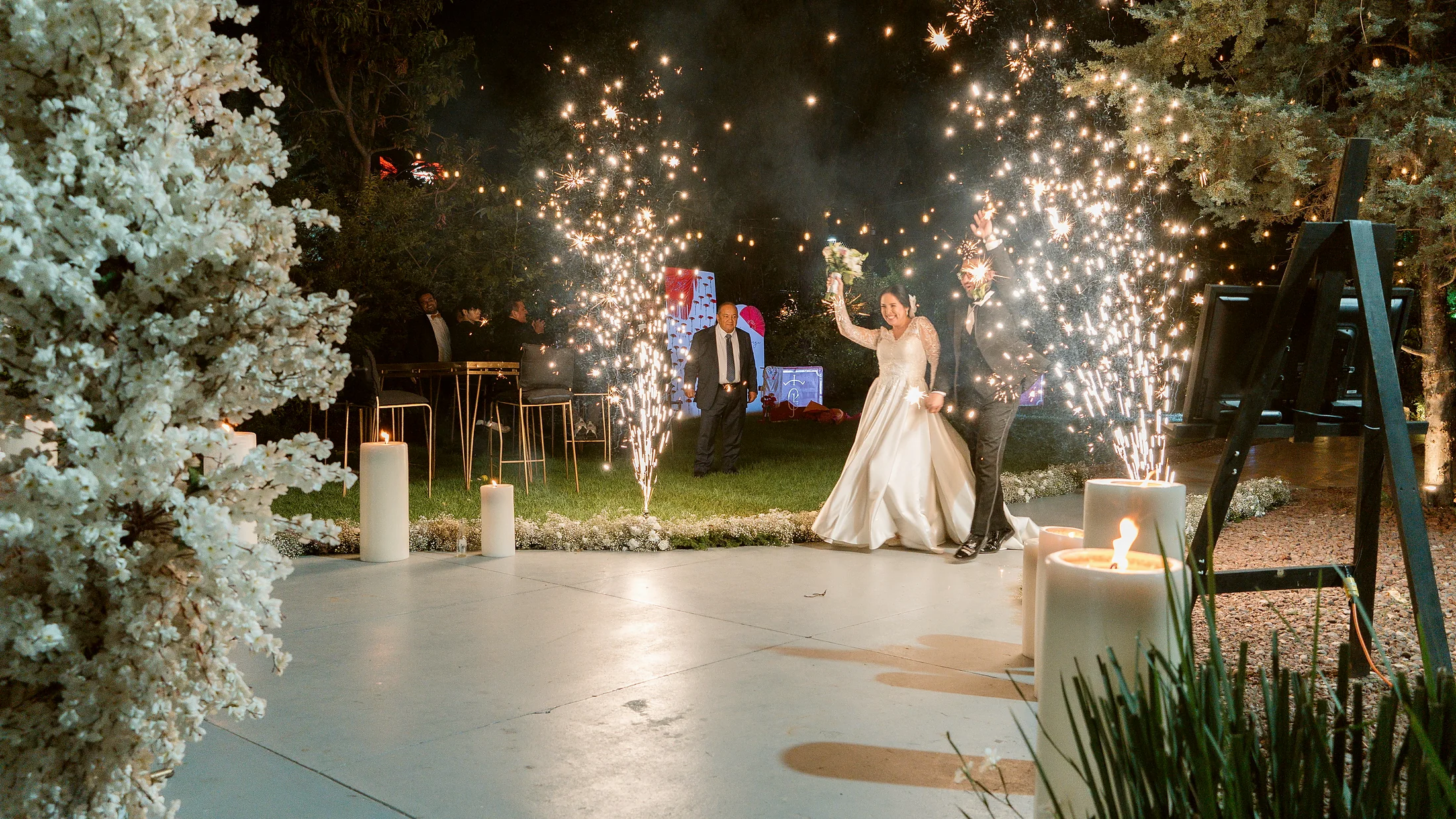 El primer baile de los novios en la pista, con chispas y columnas de flor blanca