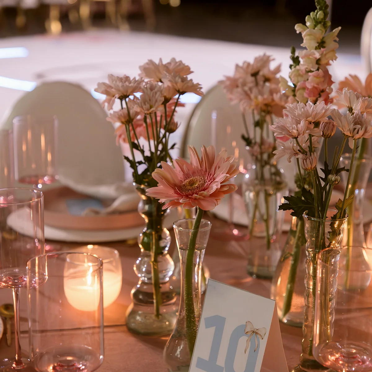 Centros de flores rosas sobre las mesas de los invitados